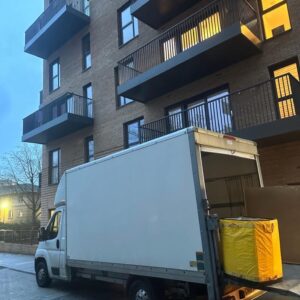 Flat removals London — Luton van outside modern apartment block at dusk