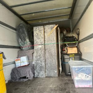 House removals — table tops, cooler box and storage crates loaded in van
