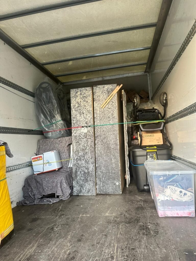 House removals — table tops, cooler box and storage crates loaded in van