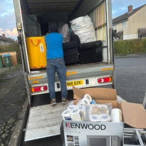 House move in progress — sofas and Kenwood microwave being unloaded from van