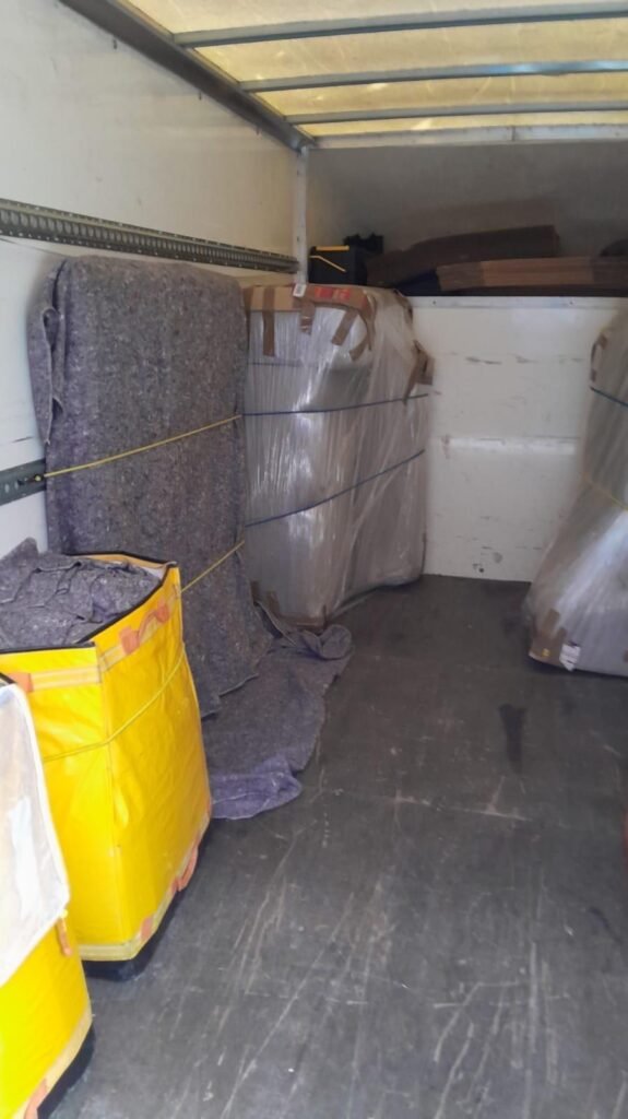 House removals van loaded with blanket-wrapped furniture — London