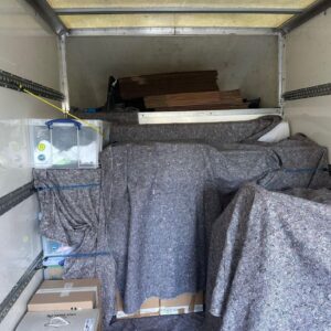 House removals van loaded with blanket-wrapped furniture — London