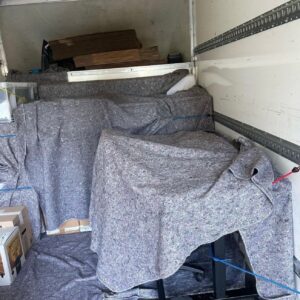 House removals van loaded with blanket-wrapped furniture — London