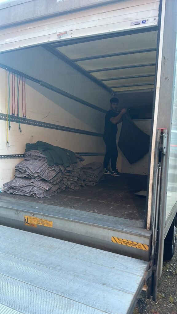 Mover folding clean removal blankets inside Luton van — Man and Van service