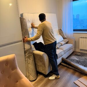 Professional packing service — mover wrapping furniture in London