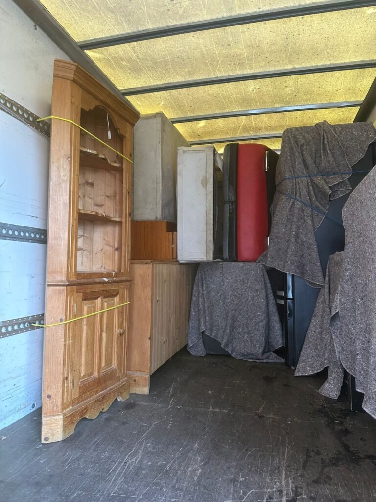 Furniture delivery London — antique wood corner cabinet loaded into van